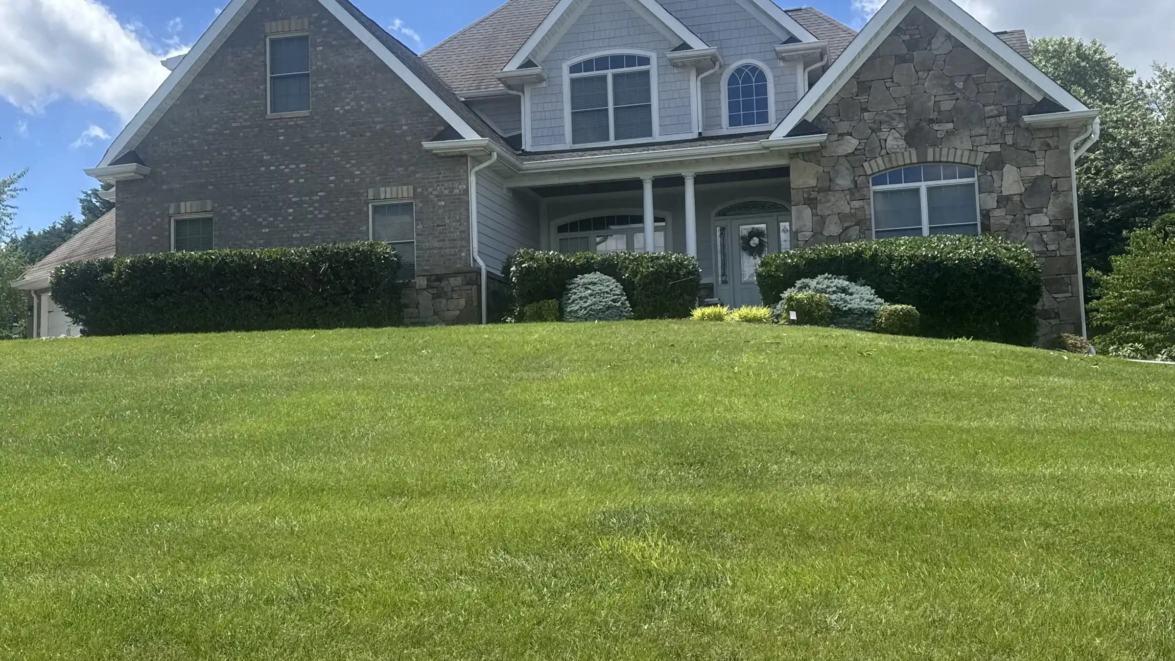 Thick green turf across a well-kept front lawn.